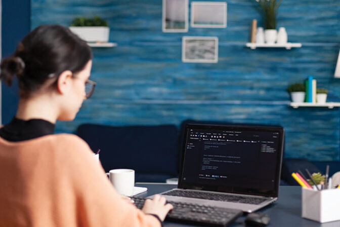 Realistic image of a person’s hand resting on a laptop keyboard with one finger of another hand approaching a search bar with the words “AI Search.