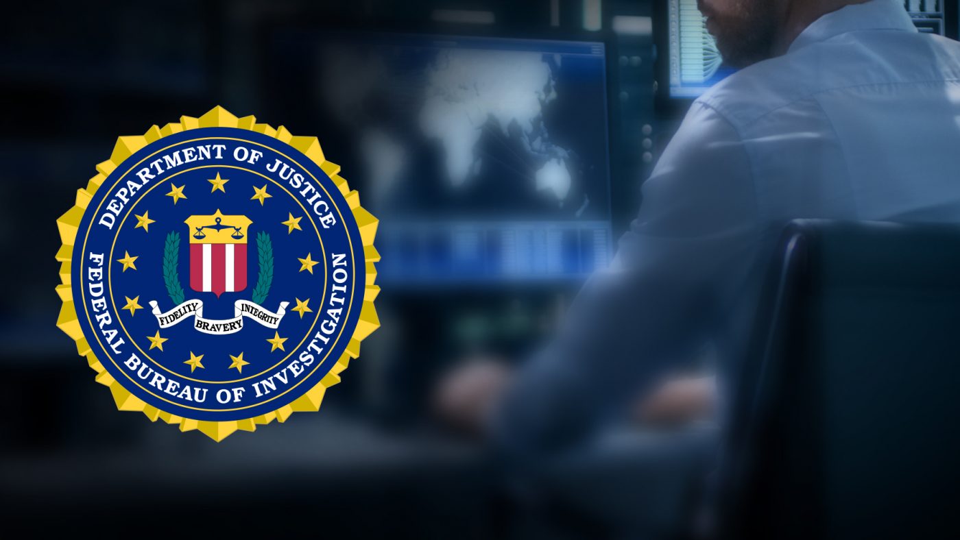 FBI Symbol Over a Man Working on a Computer