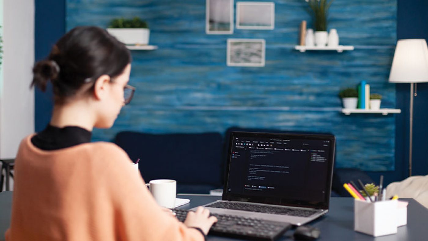 Realistic image of a person’s hand resting on a laptop keyboard with one finger of another hand approaching a search bar with the words “AI Search.